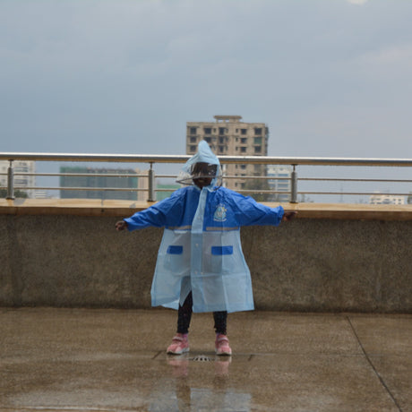Person wearing a blue raincoat on a rooftop with buildings in the background